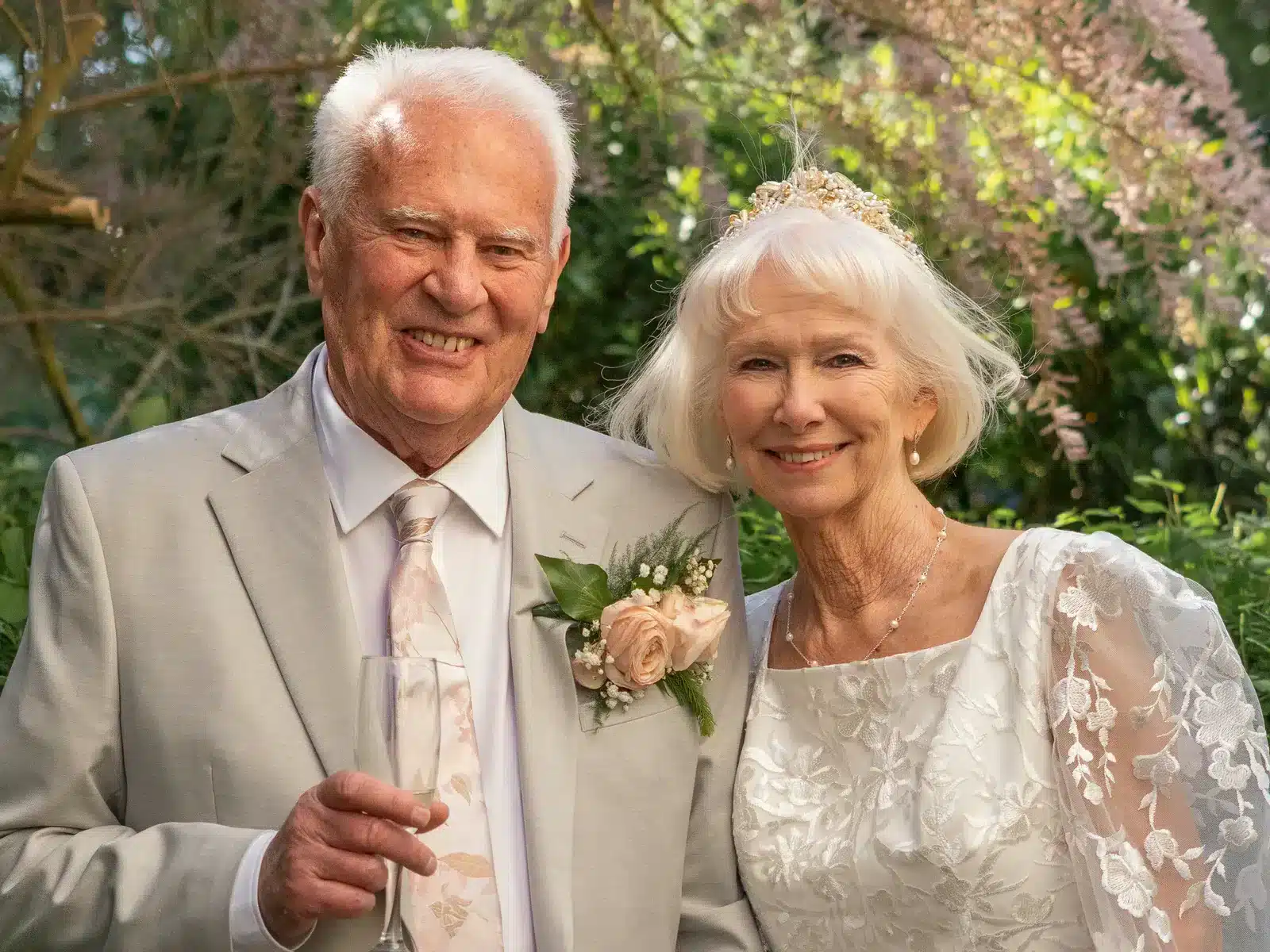 Long-married couple in wedding attire smiling together outdoors