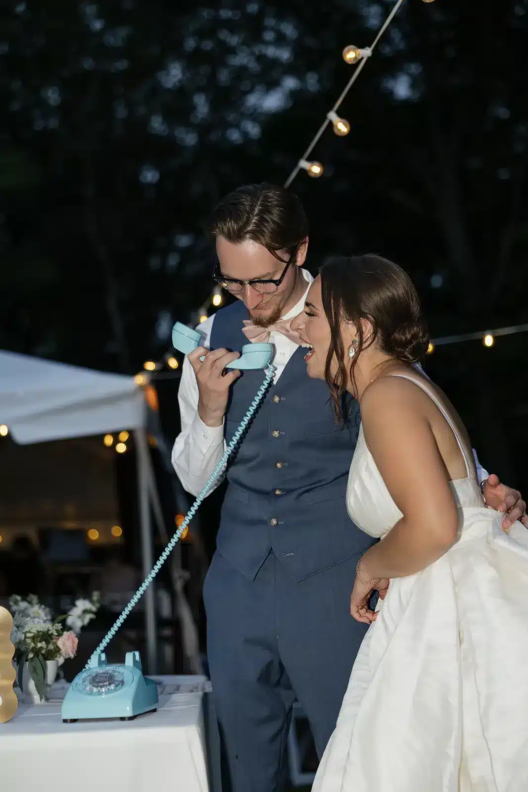 Newly married couple laughing together while holding a turquoise LifeOnRecord telephone