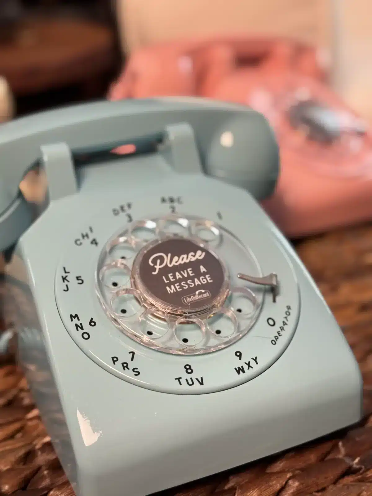 Mint rotary LifeOnRecord phone with a coral phone behind it
