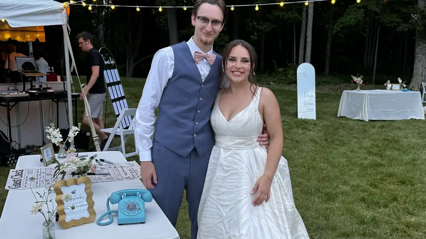 Newlyweds beside their turquoise LifeOnRecord phone at an outdoor reception
